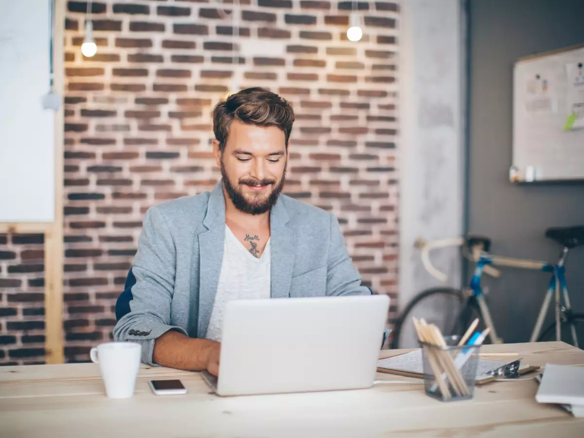 Man behind a laptop in a modern office