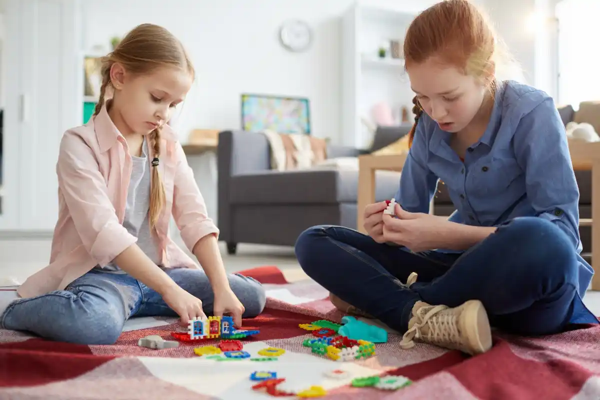 Two girls playing indoors with children toys